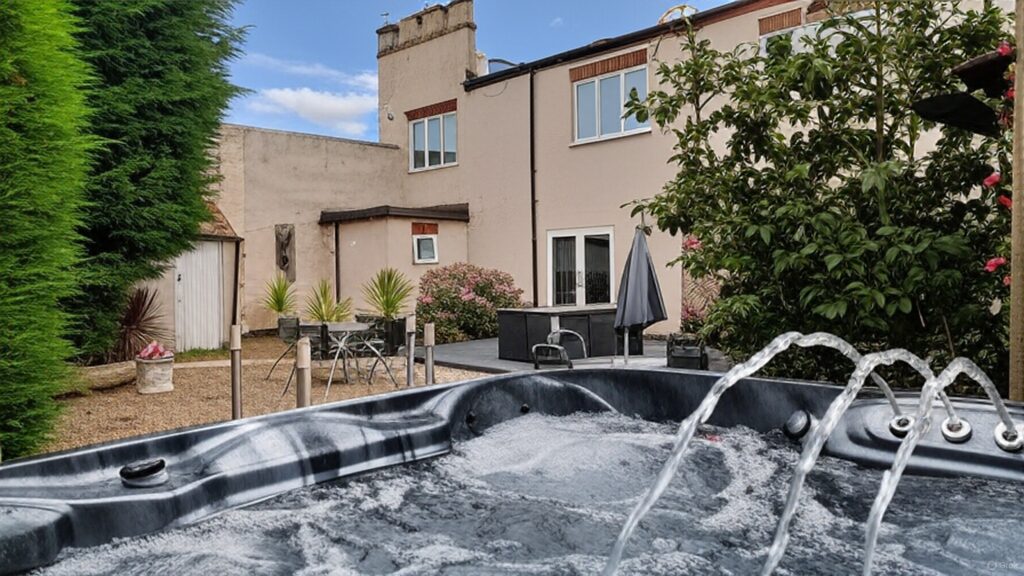 Hot tub relaxation on a sunny day in at The East Wing holiday cottage private courtyard