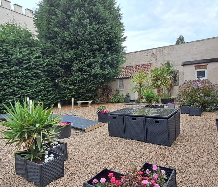 Enclosed courtyard at The East Wing with outdoor seating and planters